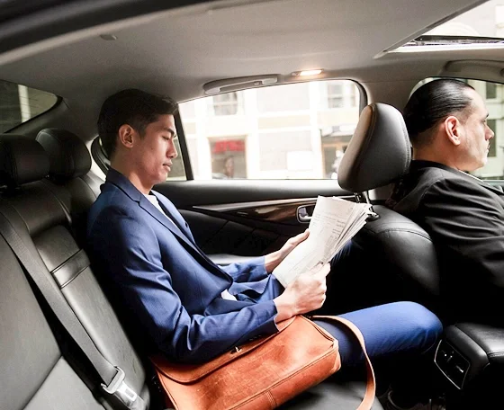 Executive reading in the rear cabin of a chauffeur-driven luxury saloon