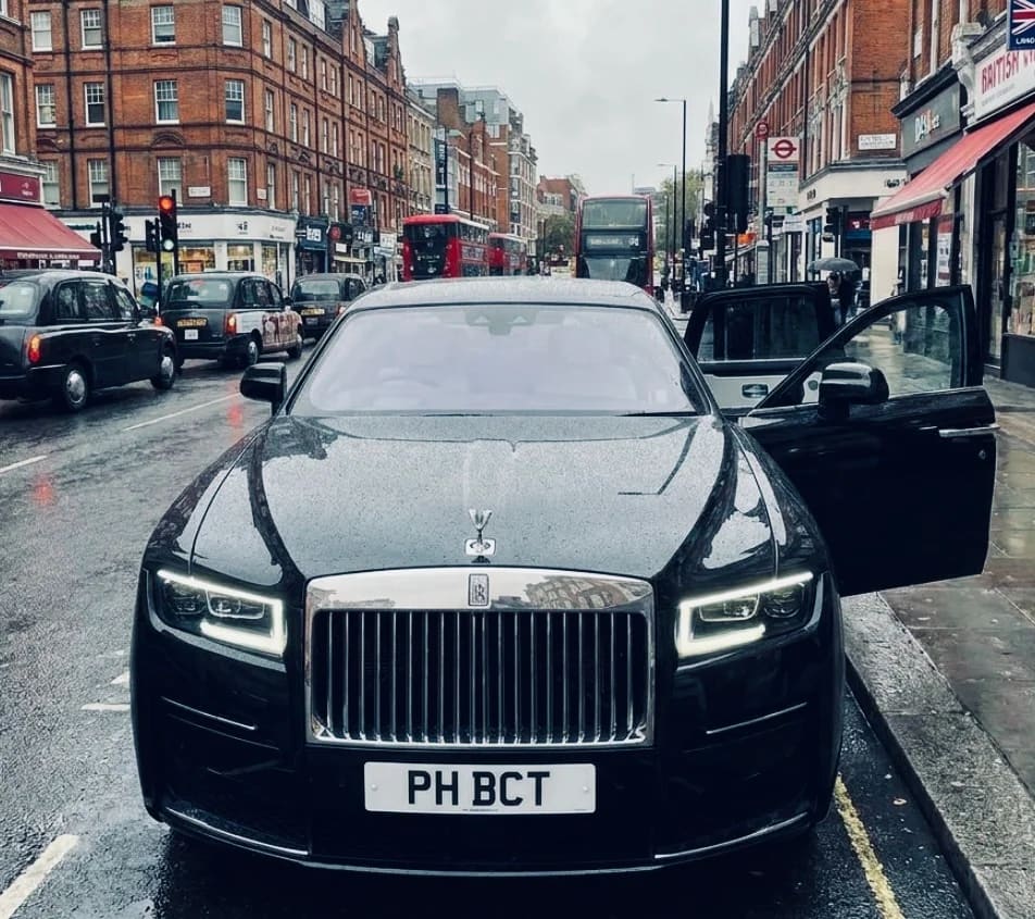 Chauffeur waiting beside a luxury saloon at a UK private terminal