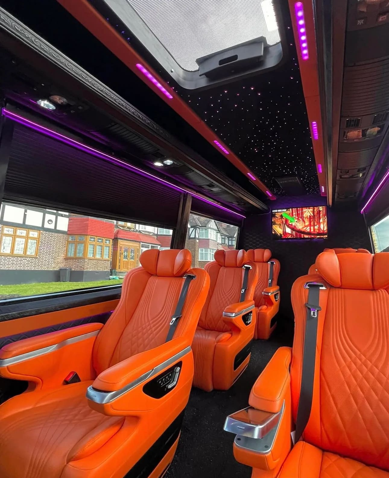 Luxury van interior with orange leather seats, starlight ceiling and skylight