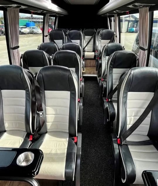 Executive coach interior with black and white leather passenger seats
