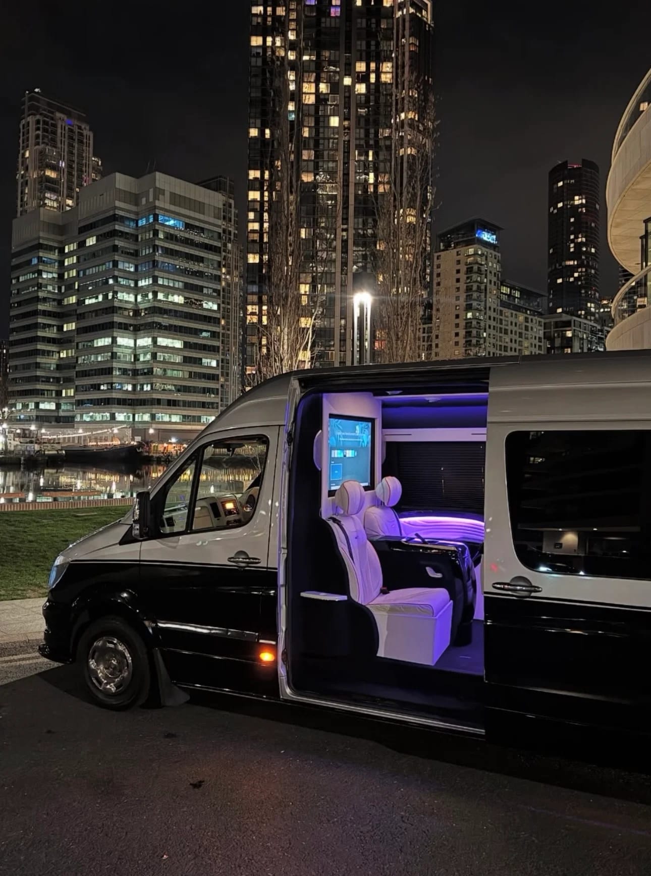 Luxury Sprinter van with purple interior lighting at night in the city
