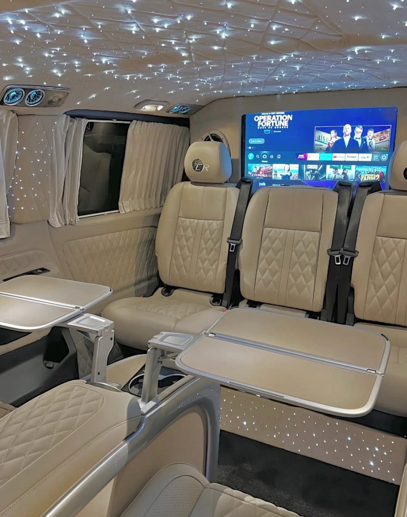Luxury VIP van interior with beige leather, starlight ceiling and entertainment screen